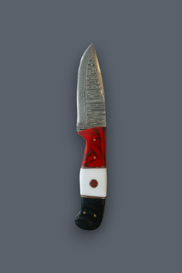 A small fixed-blade knife with a patterned steel blade, a red and white handle, and a black end, shown vertically against a solid dark gray background.