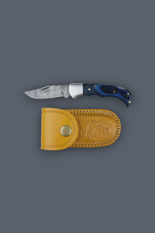 A fixed-blade knife with a textured silver blade and a dark blue handle, displayed horizontally above a tan leather sheath on a solid dark gray background.