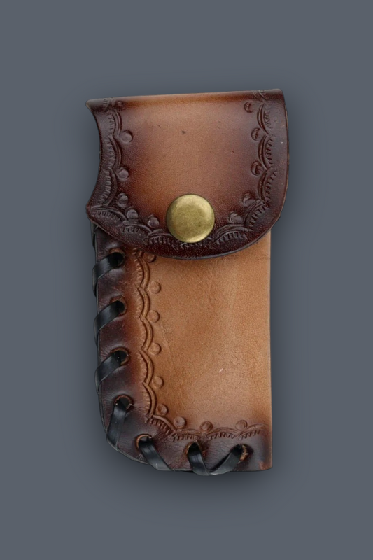 A brown leather pouch with embossed floral detailing, a brass snap button, and dark stitched edges, shown against a solid dark gray background.
