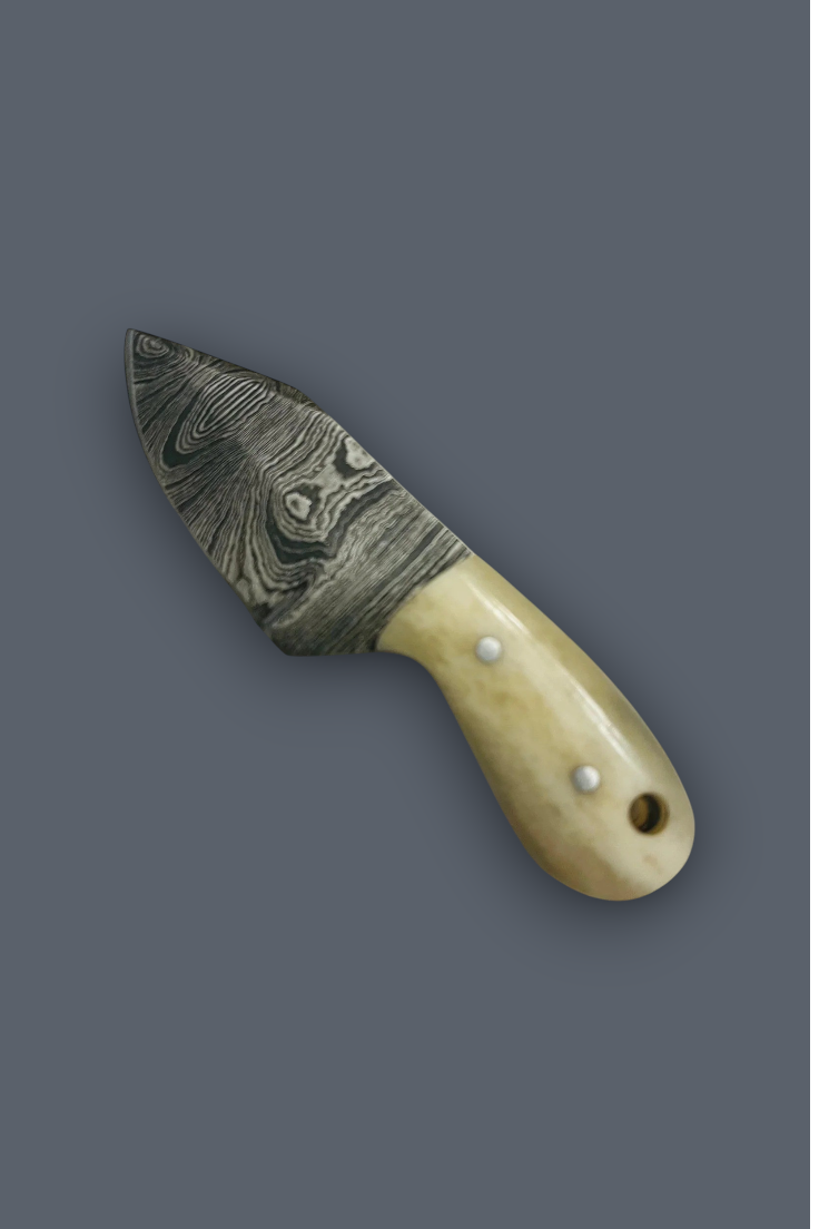 A small fixed-blade knife with a patterned Damascus-style steel blade and a cream-colored bone handle secured by three silver rivets, shown on a solid dark gray background.