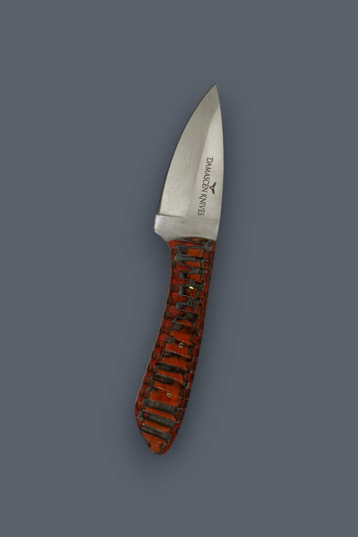 A fixed-blade knife with a satin-finished silver blade and a textured reddish-brown handle featuring black and orange inlay, shown against a solid dark gray background. The brand 'DRAAGO' is visible on the blade.