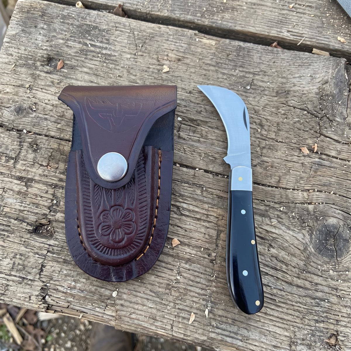 Billhawk pocket knife with black plastic handle and leather sheath

