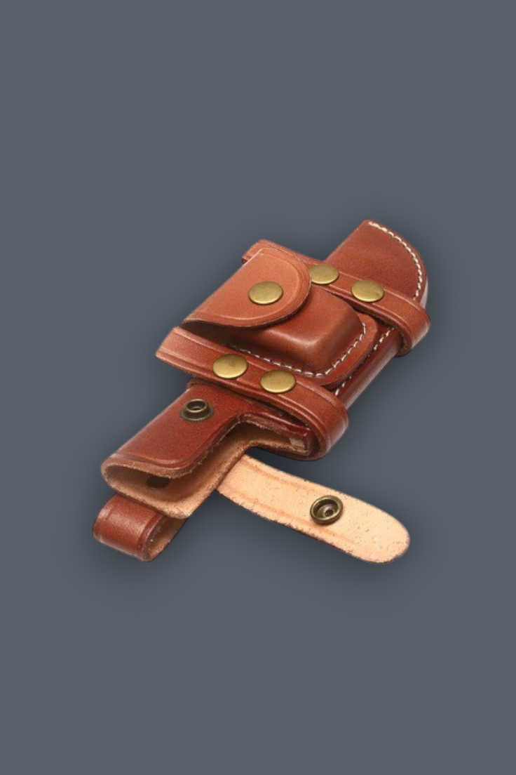 A brown leather holster with brass snap buttons and a light tan leather strap, shown on a solid dark gray background.