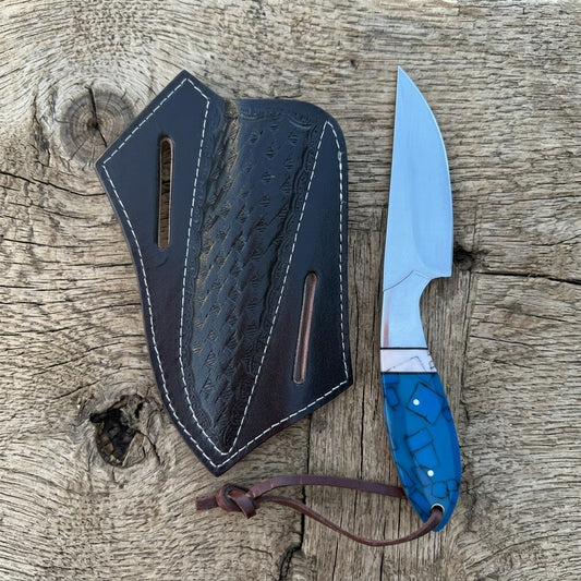 Fixed blade knife with turquoise patterned resin handle and black leather sheath

