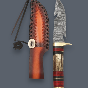 A fixed-blade knife with a patterned steel blade, a striped wooden handle with red and black accents, shown next to its brown leather sheath on a solid dark gray background.