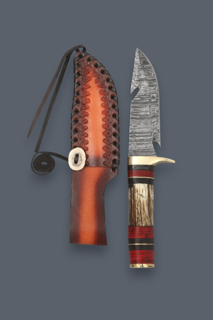 A fixed-blade knife with a patterned steel blade, a striped wooden handle with red and black accents, shown next to its brown leather sheath on a solid dark gray background.