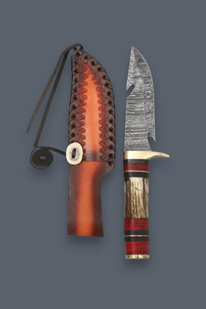 A fixed-blade knife with a patterned steel blade, a striped wooden handle with red and black accents, shown next to its brown leather sheath on a solid dark gray background.