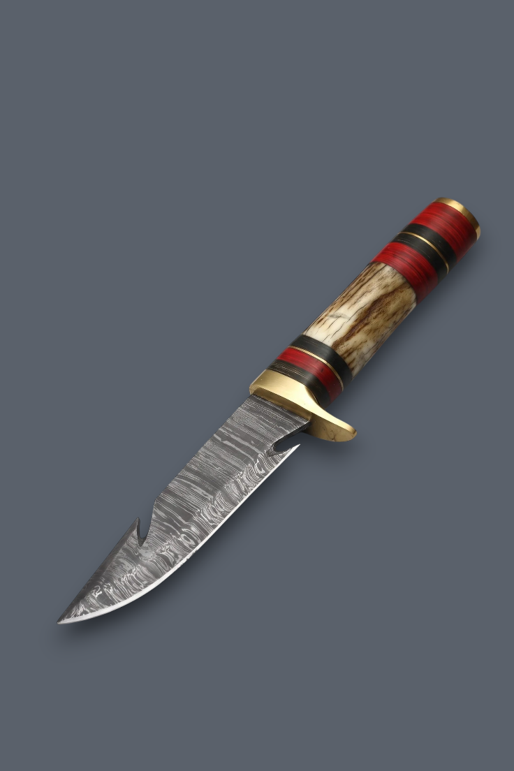 A custom fixed-blade knife with a patterned Damascus steel blade, a brass bolster, and a handle made of red, black, and natural wood inlay, shown on a solid dark gray background.