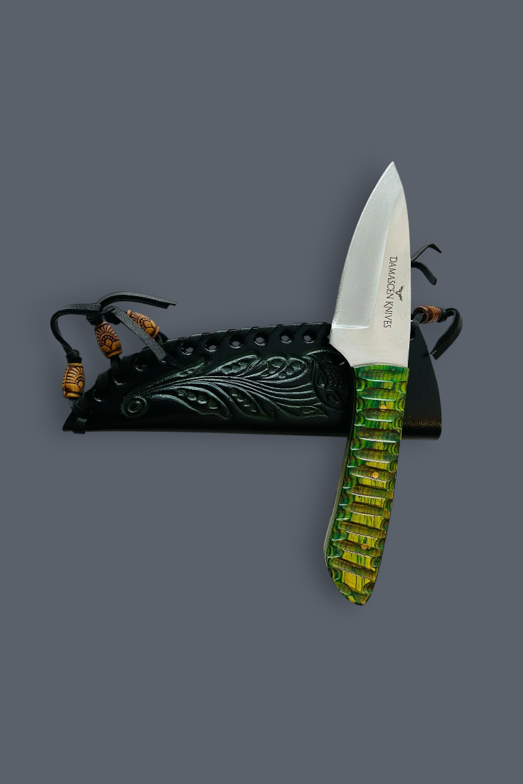 A fixed-blade knife with a silver blade and a textured green handle, displayed vertically next to its black sheath with carved details and brown cord accents on a solid dark gray background.