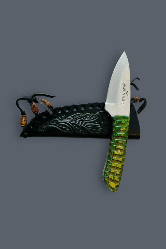 A fixed-blade knife with a silver blade and a textured green handle, displayed vertically next to its black sheath with carved details and brown cord accents on a solid dark gray background.
