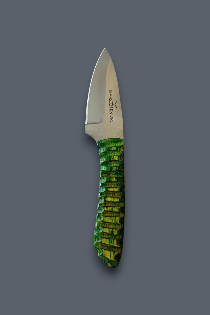 A fixed-blade knife with a satin-finished silver blade and a textured green handle with yellow-gold iridescent scales, shown on a solid dark gray background. The blade is engraved with the brand name 'DIAMONDBIT'.
