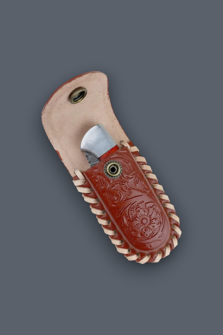 A folding pocket knife with a silver blade partially pulled from a reddish-brown tooled leather sheath, set against a solid dark gray background.