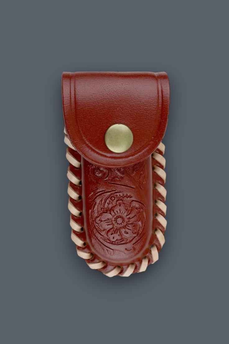 A reddish-brown leather pouch with a snap closure, featuring an embossed floral design and twisted cream-colored trim, shown against a solid dark gray background.