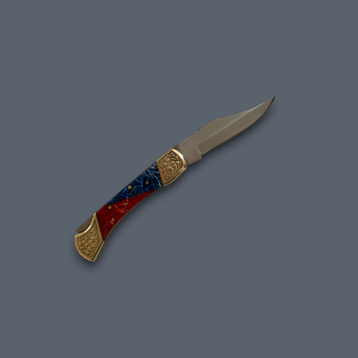 A folding pocket knife with a silver steel blade, gold-toned metal end caps, and a handle featuring a red and blue marbled pattern with gold accents, shown on a solid dark gray background.