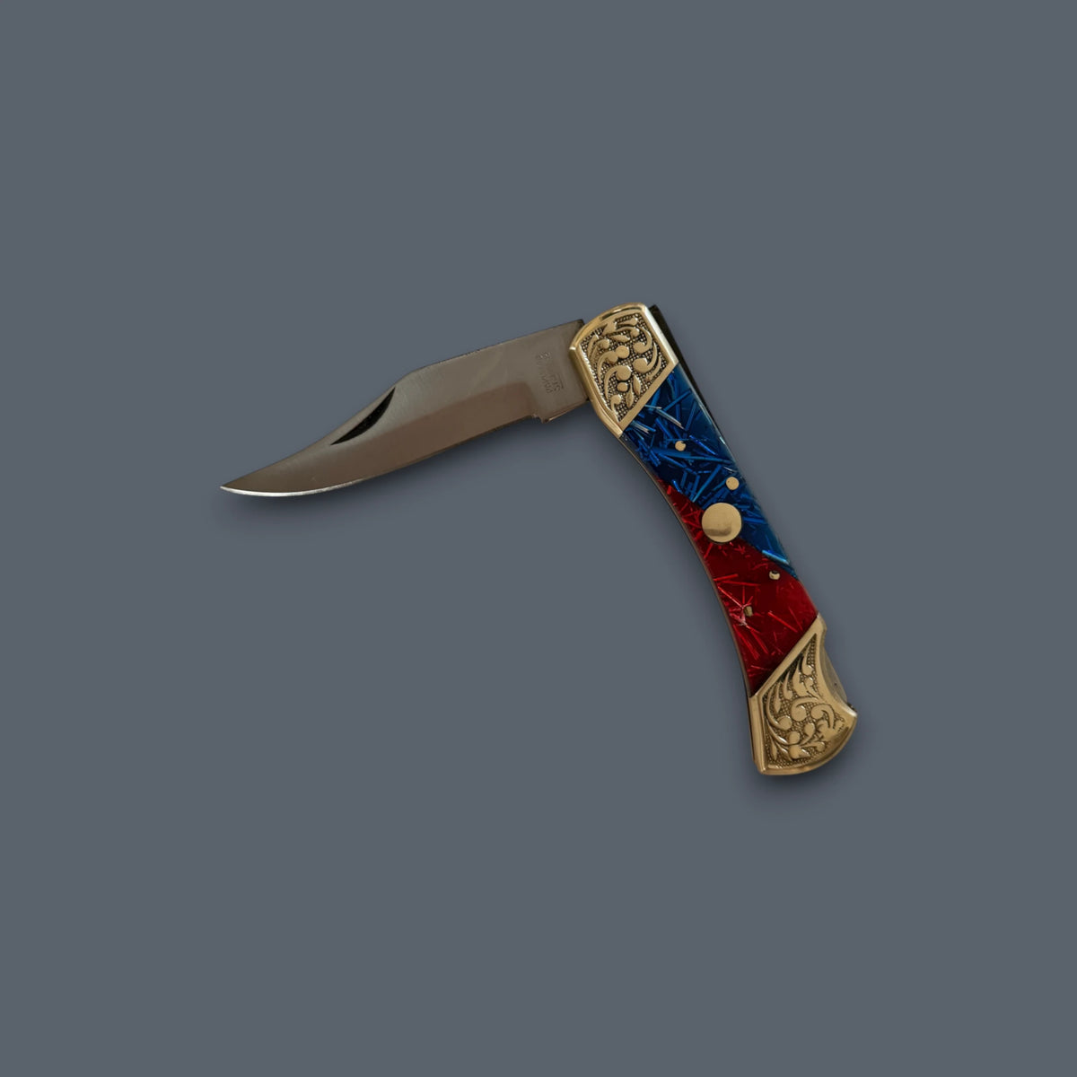 A folding pocket knife with a satin-finished steel blade and a decorative handle featuring a red and blue marbled pattern with gold-toned metal accents, set against a solid dark gray background.