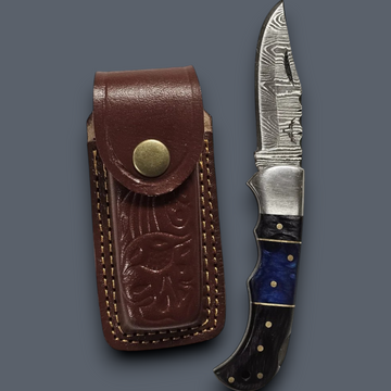 Custom Damascus folding knife featuring a blue wood handle and handcrafted leather belt sheath