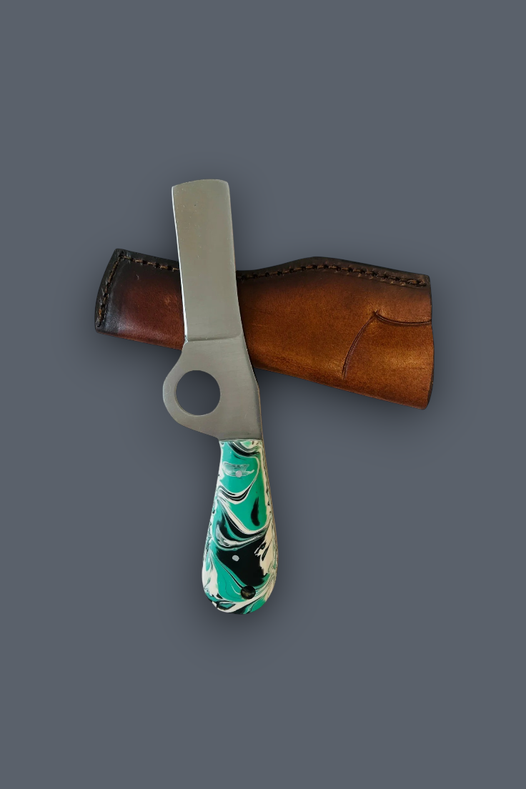 A small fixed-blade knife with a silver metal blade, a turquoise, black, and white marbled handle, and a brown leather sheath, displayed on a solid dark gray background.