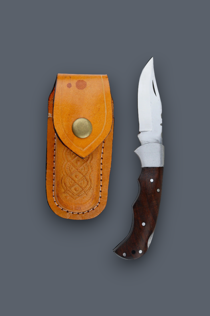 A fixed-blade knife with a silver blade and dark brown wooden handle, shown next to its tan leather sheath on a solid dark gray background.