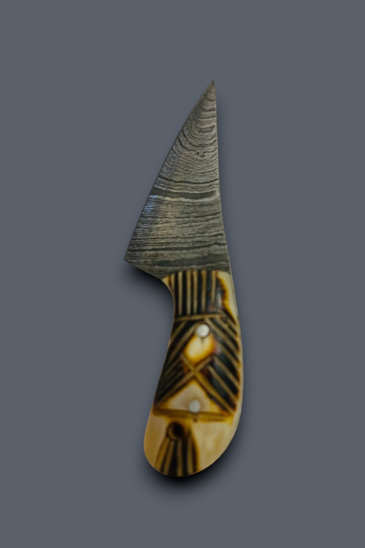 A decorative kitchen knife with a patterned steel blade and a carved handle made of brown and beige wood or bone, shown on a solid dark gray background.