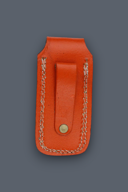 An orange leather money clip with a snap button closure and decorative chain stitching, shown against a solid dark gray background.