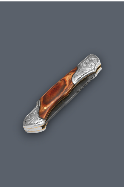 A folding pocket knife with a polished brown wood handle and ornate silver-toned metal guard and bolster, shown on a solid dark gray background.