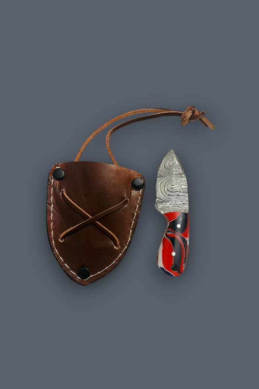 A fixed-blade knife with a patterned steel blade and red-and-black handle, shown next to a brown leather sheath with a loop strap on a dark gray background.