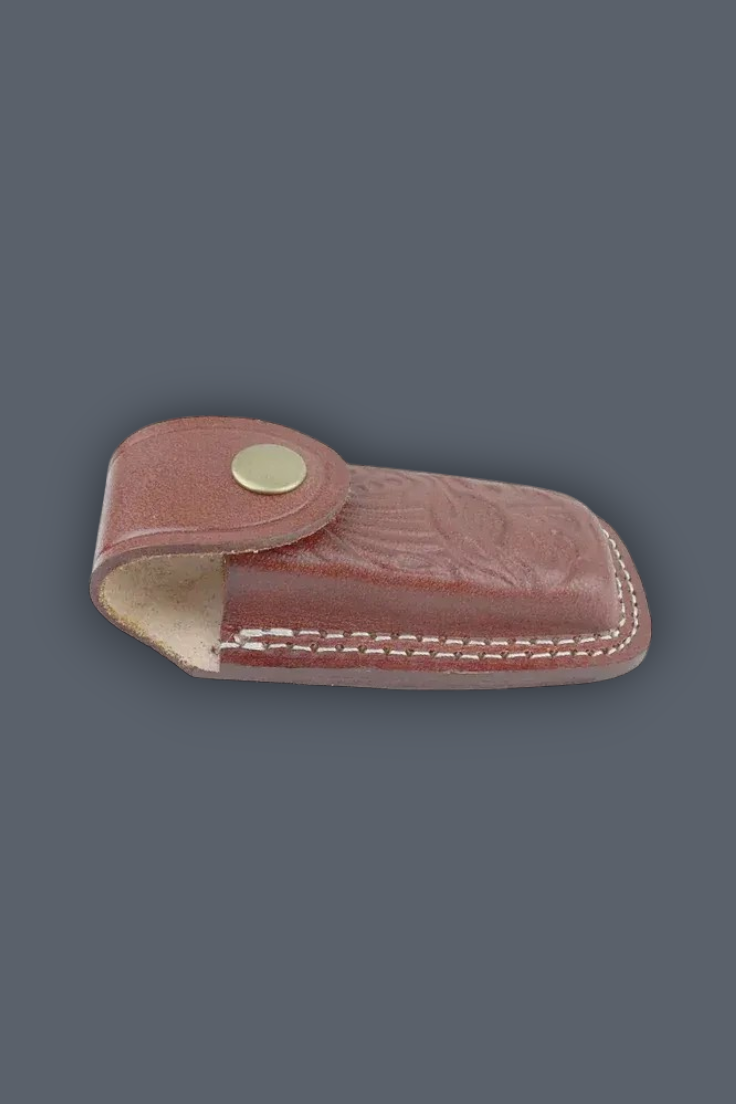 A reddish-brown leather knife sheath with white stitching and a brass snap button, shown on a solid dark gray background.