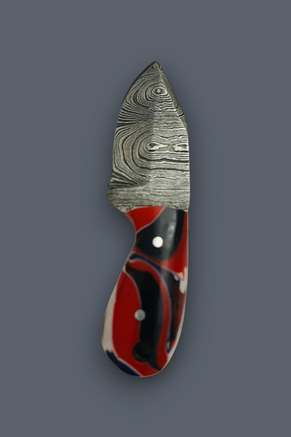 A small fixed-blade knife with a patterned Damascus steel blade and a red, black, and white marbled handle, shown against a solid dark gray background.