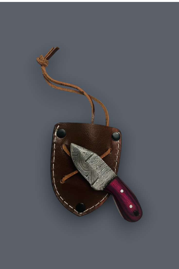 A fixed-blade knife with a patterned steel blade and a dark purple handle, tucked inside a brown leather sheath with a tan lanyard, shown on a solid dark gray background.
