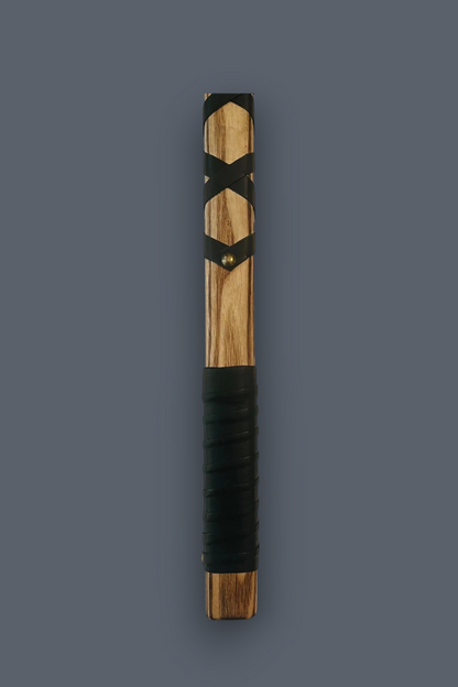 A wooden sword practice sword (bokken) with a natural wood grain handle, black leather-wrapped details, and a black textured grip, shown vertically against a solid dark gray background.