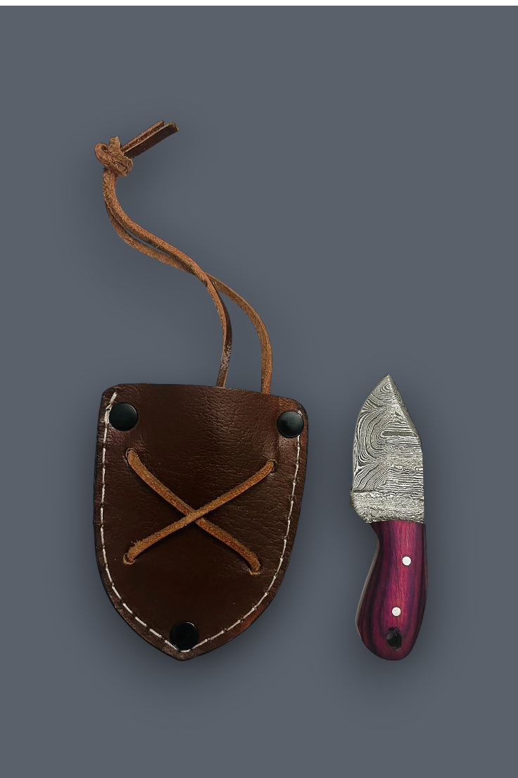 A small fixed-blade knife with a patterned steel blade and a purple handle, shown next to its brown leather sheath on a dark gray background.