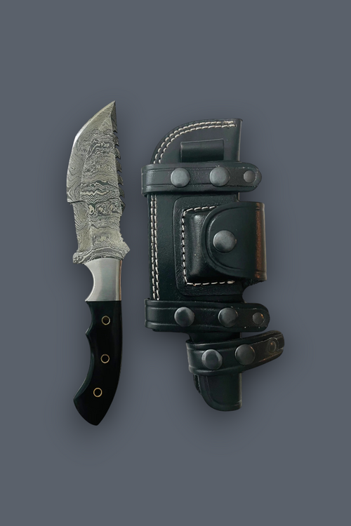 A fixed-blade knife with a patterned steel blade and black handle, shown next to its dark green leather sheath with metal snaps, on a solid dark gray background.