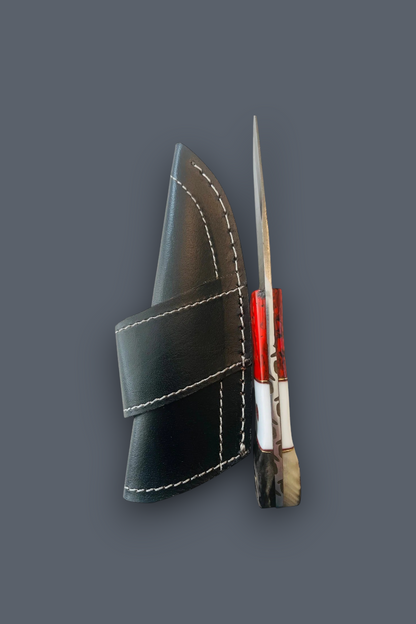 A small knife with a red handle and silver blade, shown next to a black leather sheath with white stitching, on a solid dark gray background.