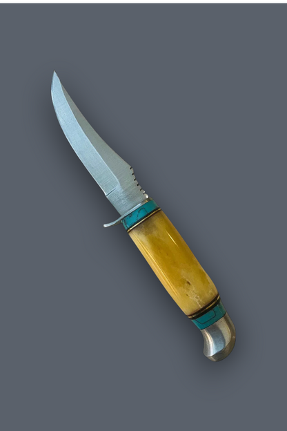 A fixed-blade knife with a curved silver steel blade, a yellow bone handle, and turquoise blue inlay bands, shown diagonally on a solid dark gray background.