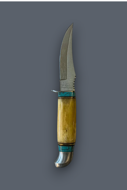 A fixed-blade knife with a curved silver steel blade, a natural bone handle showing warm yellow and beige tones, and turquoise-colored inlay bands, set against a solid dark gray background.