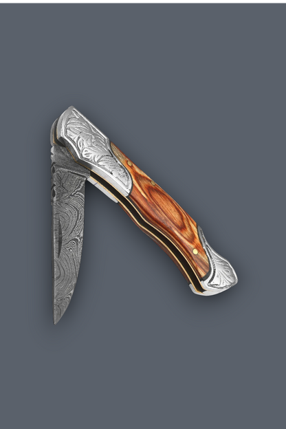 A folding pocket knife with a Damascus steel blade and a polished wood handle, shown against a solid dark gray background.