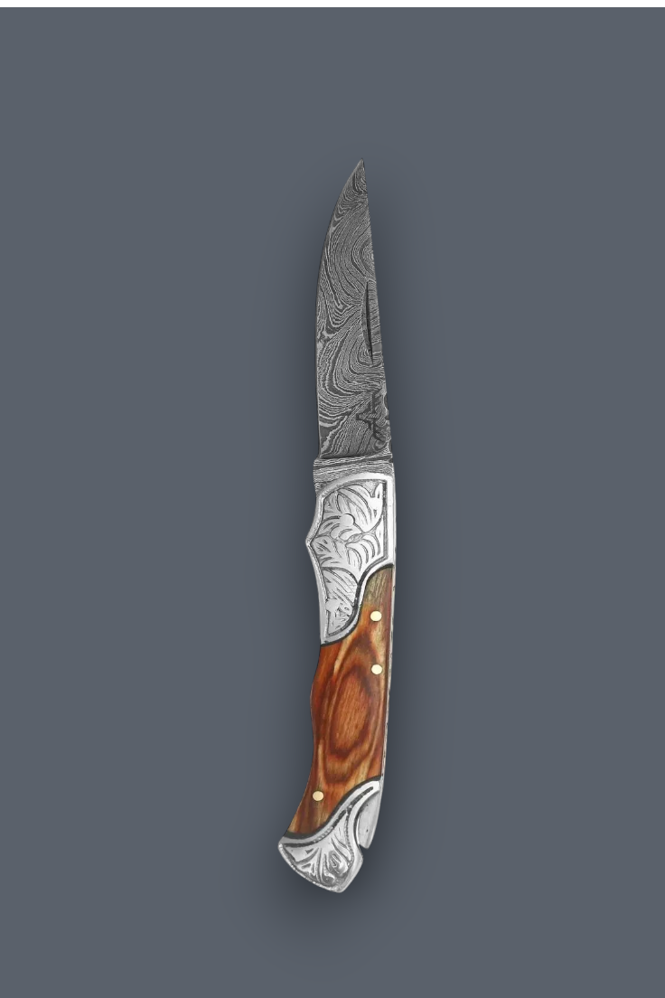 A folding pocket knife with a patterned Damascus steel blade, an engraved silver metal bolster, and a brown wood handle, shown against a solid dark gray background.