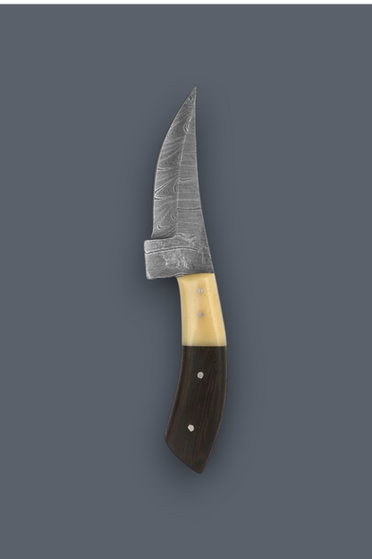 A fixed-blade knife with a patterned steel blade, a cream-colored bone handle section, and a dark brown wooden handle, shown against a solid dark gray background.