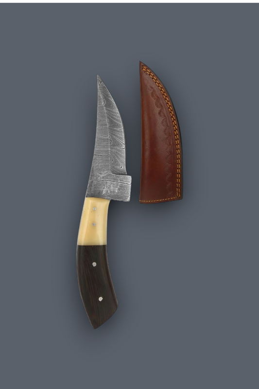 A fixed-blade knife with a patterned steel blade, a cream-colored middle section, and a dark brown handle, shown next to its brown leather sheath on a solid dark gray background.