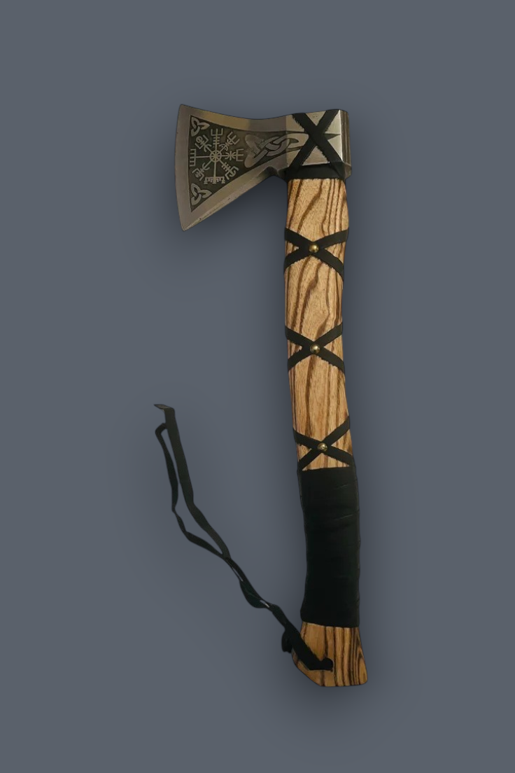 A decorative hand axe with a silver-toned engraved metal head, a light wood handle, black woven bands, and a black wrapped grip, shown on a plain dark gray background.