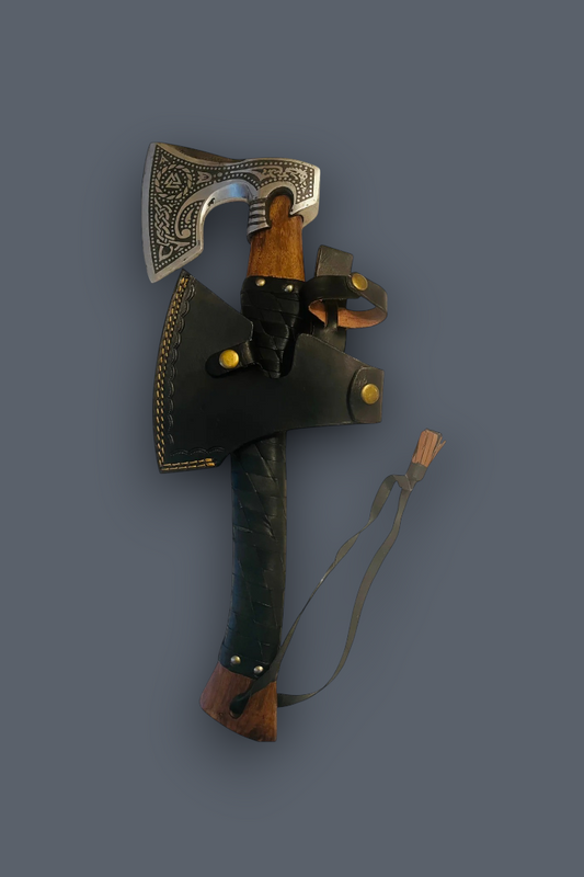 A decorative axe with an engraved silver blade, a brown wooden handle, and a black leather sheath with brass studs, shown against a solid dark gray background.