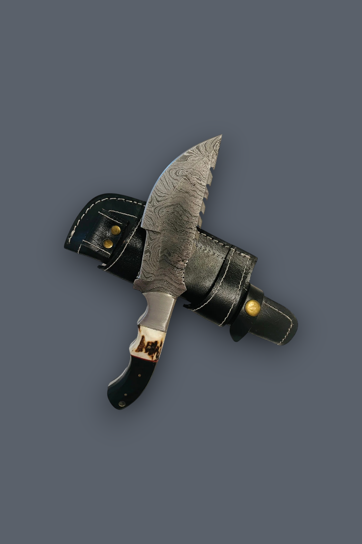 A fixed-blade knife with a patterned steel blade, black handle, and brass guard, shown crossed over a black leather sheath on a solid dark gray background.