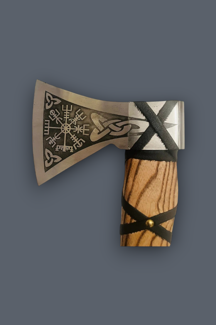 A Viking-style axe with a silver-toned engraved metal head, a light brown wood handle, and black leather wrap details, shown against a solid dark gray background.