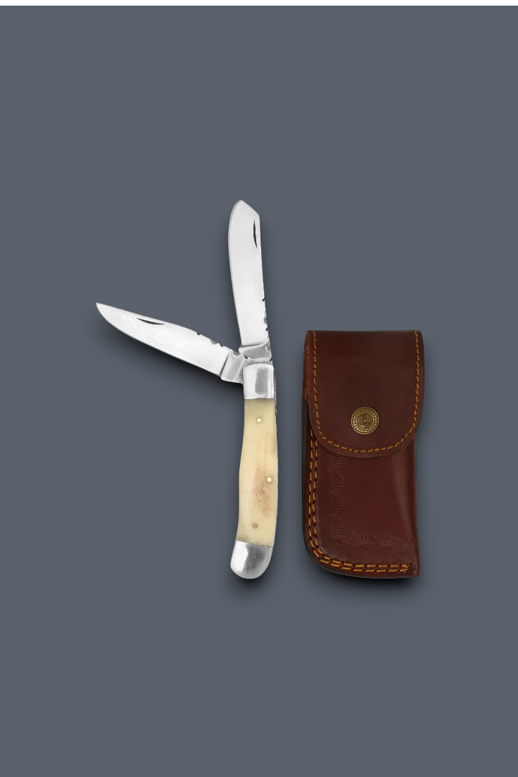 A folding pocket knife with a cream-colored bone handle and a silver stainless steel blade, shown next to its brown leather sheath on a solid dark gray background.