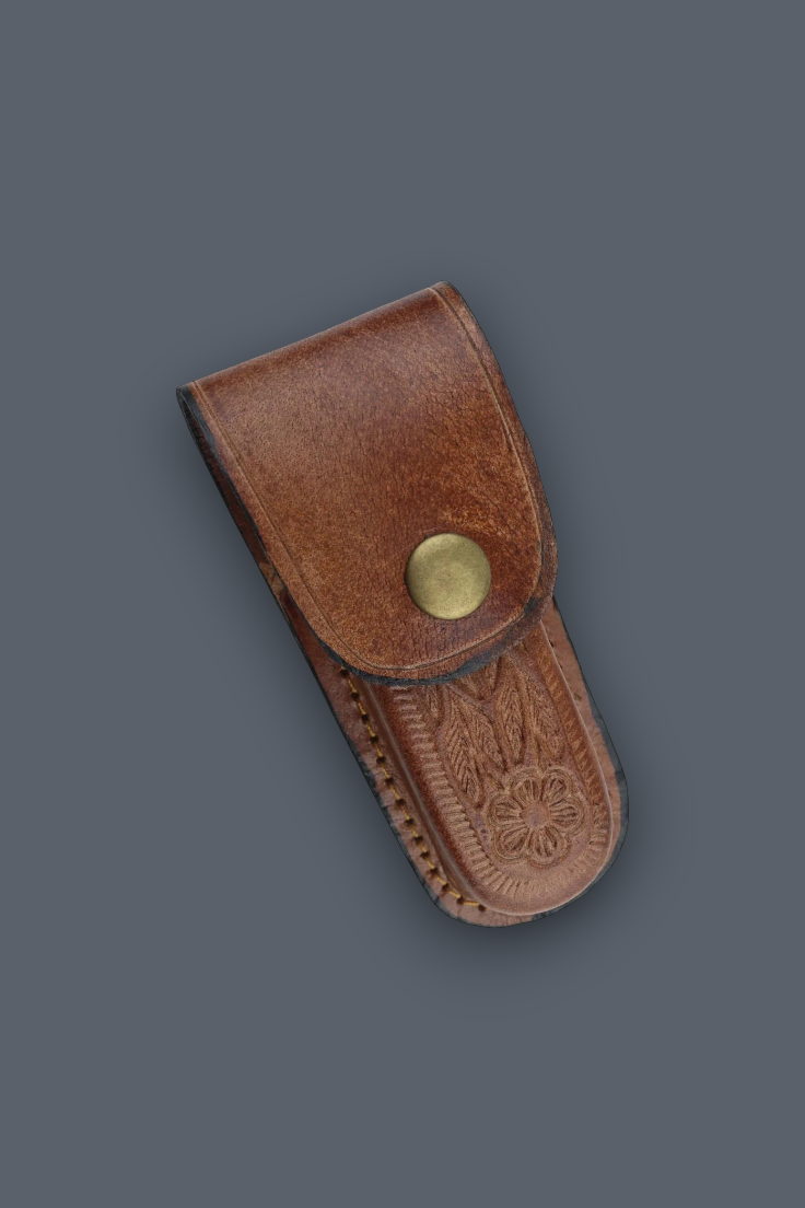 A brown leather pouch with a snap button closure and embossed floral detailing, shown on a solid dark gray background.