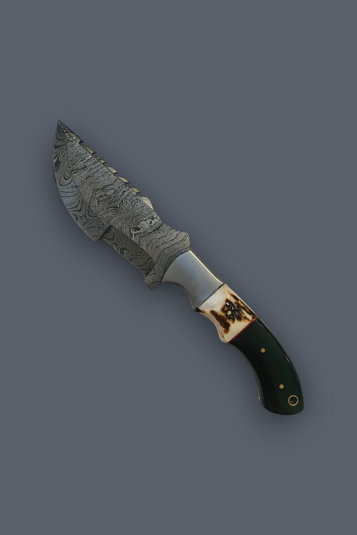 A decorative fixed-blade knife with a patterned steel blade, a silver bolster, a cream-colored bone guard with dark inlay, and a dark green handle, shown on a solid dark gray background.