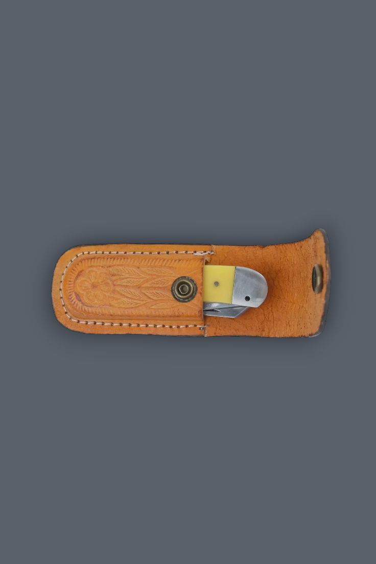 A tan leather knife sheath containing a folding pocket knife with a yellow handle, set against a solid dark gray background.