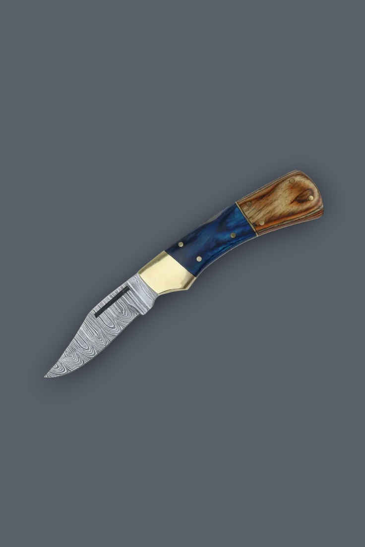 A folding pocket knife with a patterned steel blade, a polished brass bolster, and a handle made of blue marbled resin and natural wood, shown on a solid dark gray background.
