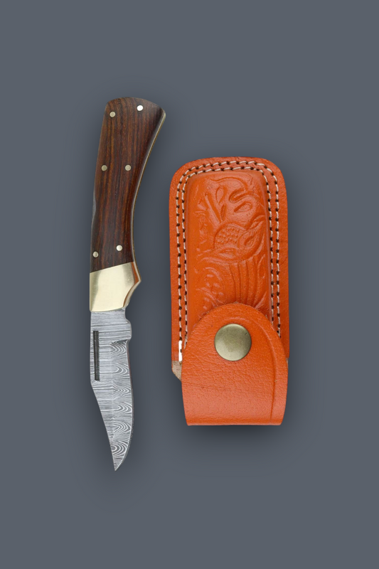 A fixed-blade knife with a patterned steel blade, dark wood handle, and brass bolster, shown next to its orange leather sheath on a dark gray background.