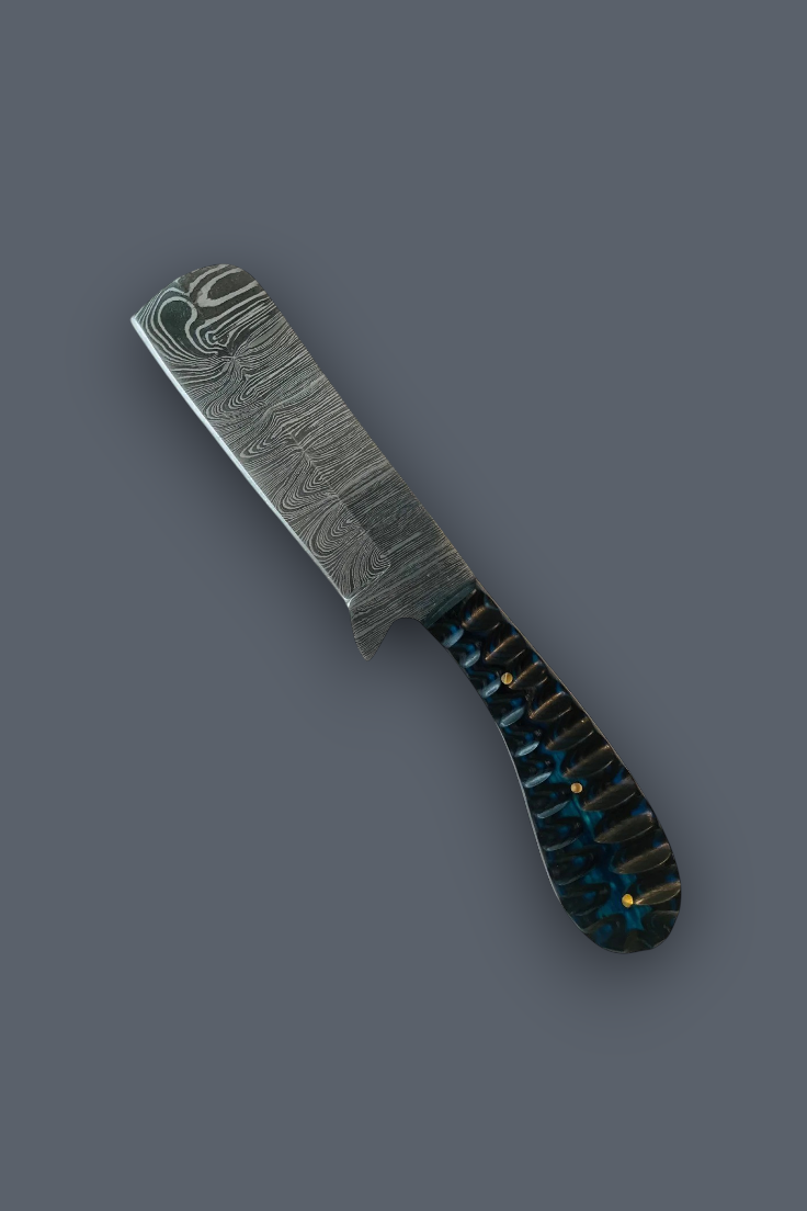 A Damascus steel folding knife with a patterned steel blade and a dark handle featuring blue, black, and gold inlay, shown on a solid dark gray background.
